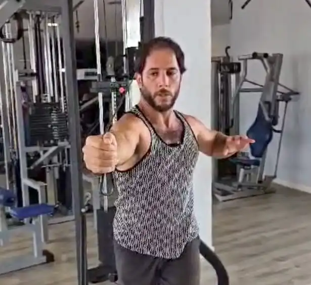 Jean Pierre mostrando entrenamiento de tríceps en polea alta con cuerda